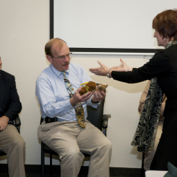 Wendy Dolci, former KAO mission director, presents SOFIA program manager Bob Meyer with two KAO mascots to be flown on SOFIA. 